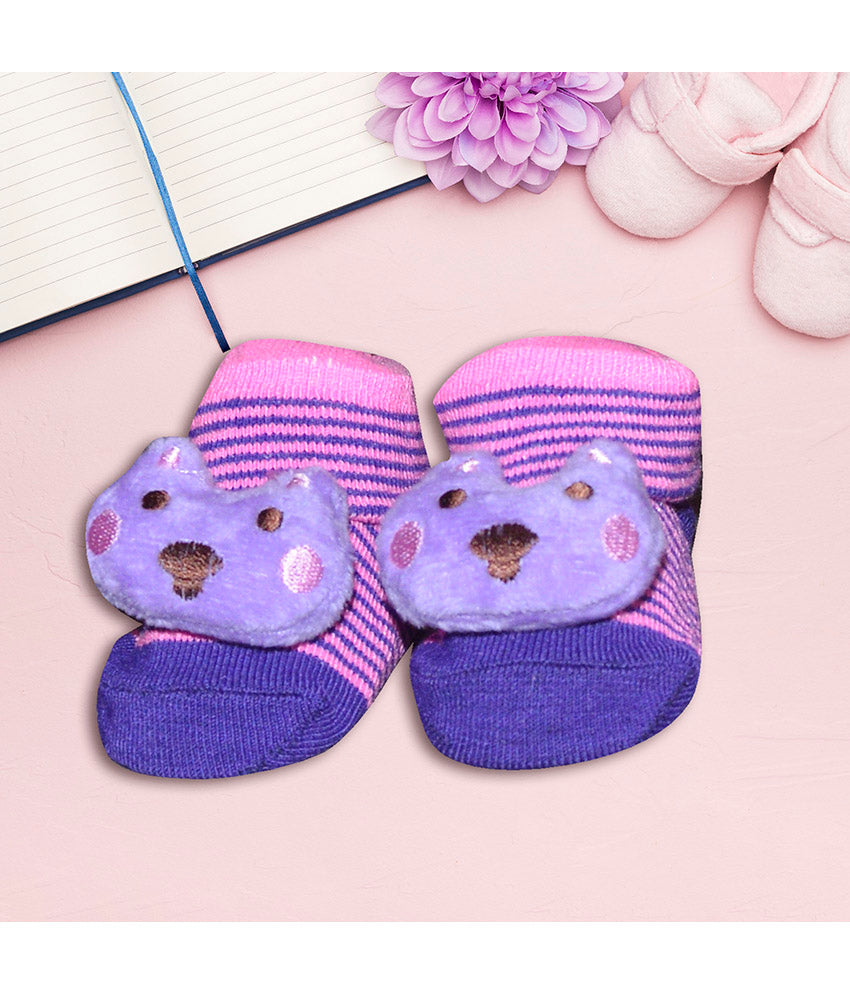 Pair of purple and pink baby socks with bear faces