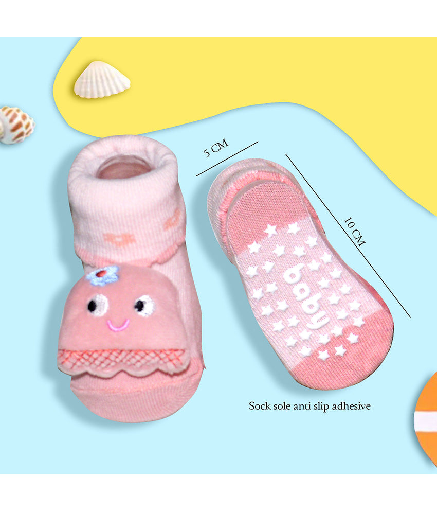 Pink baby socks with smiley face design and star pattern on sole